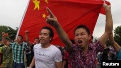 资料照:中国广东省深圳市的抗议者手举中国旗帜参加反日集会。(2012年8月19日)