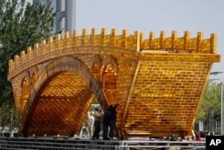 2017年4月18日,工人们在中国国家会议中心外头的平台上,为丝绸之路黄金大桥装置缆线。北京将于5月在国家会议中心举办一带一路峰会。
