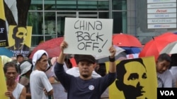 菲律宾人6月12日在中国驻马尼拉领事馆前示威,有人举着的标语牌上写着:中国,撤回去。