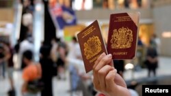 一名香港示威者在反对港版国安法的抗议中手举英国国民海外护照。(2020年6月1日)