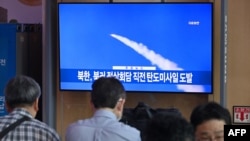 资料照片:2023年9月13日,在首尔的一个火车站,人们观看播放新闻的电视屏幕,其中包含朝鲜导弹试验的档案片段。韩国军方12月18日表示,朝鲜一天前向海上发射了武器后,周一又发射了一枚疑似远程弹道导弹。 (法新社摄影)
