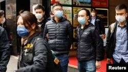 2021年12月29日被香港警方国安处拘捕的六名《立场新闻》现任和前任高层,包括代理总编辑 林绍桐(图中)被警察从办公室带走。 (路透社照片)