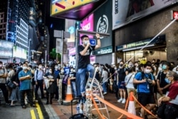 黄之锋在香港铜锣湾街头讲话,当时附近的维多利亚公园正在举行当局以新冠疫情为由禁止的纪念六四烛光集会。(2020年6月4日)