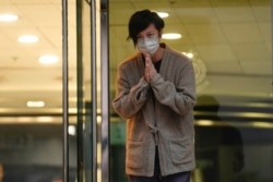 香港民主活动人士、歌手何韵诗获保释后走出警察局时向支持者鞠躬致谢。(2021年12月30日)