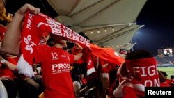 香港球迷在香港队对巴林队的国际足球友谊赛上播放中国国歌时用旗子遮住脸发出嘘声。 (2017年11月9日)