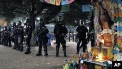 美国“占领华尔街”抗议活动从去年9月开始,加州奥克兰警察身穿防暴衣和抗议者对峙(2011年11月3号资料照)