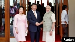 中国国家主席习近平访问印度,和印度总理纳伦德拉•莫迪(右)握手。站在左边的是习近平夫人彭丽媛(2014年9月17日)