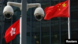 资料照:在香港政府总部大楼外监控摄像头后的中国国旗和香港特区旗帜。