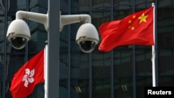 资料照:在香港政府总部大楼外监控摄像头后的中国国旗和香港特区旗帜。