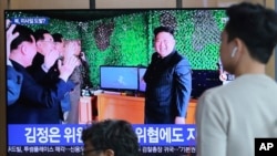 人们在韩国首尔火车站观看电视,电视上播放了朝鲜领导人金正恩在新闻节目中报道朝鲜导弹发射的照片。(2019年5月5日)