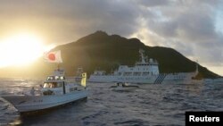 中国海监船51号(中)在东中国海域的钓鱼岛,日本称作尖阁列岛的有争议海岛旁航行,日本海岸警卫队的船只在旁(右),前船为日本渔船。(2013年7月1日)