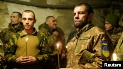 Військовослужбовці 72-ї окремої механізованої бригади "Чорні Запорожці" на святвечірній месі, Донецька область, Україна, 24 грудня 2024 року. Valentyn Kuzan/Press Service of the 72nd Chorni Zaporozhtsi Separate Mechanized Brigade of the Ukrainian Armed Forces/Handout via REUTERS