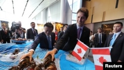 在G20杭州峰会的一次会外活动中,加拿大总理贾斯廷·特鲁多(Justin Trudeau)和阿里巴巴主席马云在阿里巴巴的西溪园区拿龙虾(2016年9月3日)。马云和特鲁多分别列为2017年《财富》全球50领袖榜的第二名和第31名。