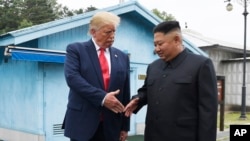 资料照:美国总统特朗普和朝鲜领导人金正恩在板门店会晤握手。(2020年1月11日)