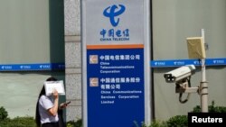 一名女子走过北京的中国电信办公楼。(2020年8月11日)