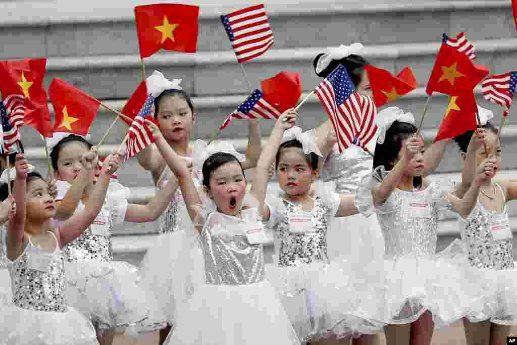 在越南主席府举行的欢迎美国总统川普的仪式之前,儿童挥舞两国国旗(2017年11月12日)。