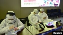 中国黑龙江省哈尔滨机场的公安人员身穿防护服进行旅客登记。(2020年4月11日)