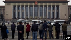 北京天安门广场上的人们观察警察在人民大会堂检查访问者(2013年11月9日)