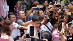 印尼副总统候选人、现任总统佐科·维多多(Joko Widodo)的儿子(中)在投票后被支持者簇拥。(美联社)