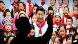 在北京展览馆前面,人们前往参观《砥砺奋进的五年》大型成就展里有中国主席习近平带着少先队的红领巾和少年儿童的合影(2017年10月23日)