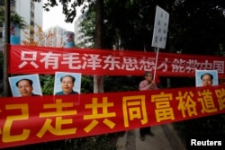 资料照:中国毛派人士手举毛泽东画像和标语横幅在广州南方周末报社外举行抗议集会。(2013年1月9日)