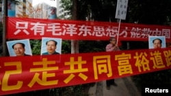 资料照:中国毛派人士手举毛泽东画像和标语横幅在广州南方周末报社外举行抗议集会。(2013年1月9日)
