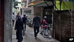 人们走过纽约地铁炸弹袭击案嫌疑人乌拉曾在孟加拉国达卡居住的楼房。(2017年12月12日)