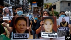 香港示威者在中联办前手举中国维权律师和异议人士的照片抗议国安法。(2020年6月25日)
