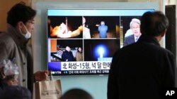 人们在首尔火车站观看有关朝鲜发射导弹的电视新闻。(2017年11月30日)