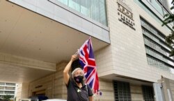 香港社运人士王婆婆9月23日在西九龙裁判法院大楼外,高举英国旗声援民主派初选47人案的被告 (美国之音/汤惠芸)