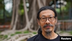 中国劳工权益活动人士韩东方在六四事件32周年之际在香港维多利亚公园外拍照。(2021年6月4日)