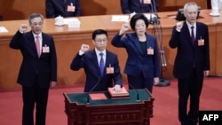 现任排名第三的中国国务院副总理胡春华(左一)被认为是出任下届中国总理的热门人选。图为现任中国排名第一的副总理韩正率领副总理孙春兰、胡春华、刘鹤和国务委员们在中国第十三届全国人民代表大会第一次会议第七次全体会议上宣誓就职(2018年3月19日)。