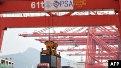 2021年9月7日,一台起重机在中国江苏省连云港市的港口将集装箱装载到卡车上。(法新社照片)