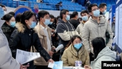 2023年2月9日,在中国湖北省武汉市的招聘会上,求职者在雇主的展台前。