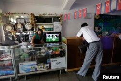 一名朝鲜妇女在平壤一家商店等候顾客。(2013年7月29日)