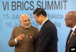 印度总理莫迪和中国国家主席习近平在巴西出席金砖五国会议领导人合影期间交谈。(2014年7月15日)