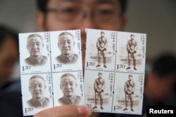 2013年10月15日,有人手持中国前副总理习仲勋的纪念邮票。习仲勋是中国领导人习近平的父亲。
