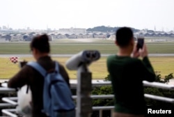 人们在日本南部冲绳岛的观景台遥望嘉手纳空军基地机场。(2018年3月24日)