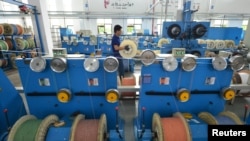 中国浙江省湖州市的一个通讯设备厂光纤生产线上的工人在工作。(2020年5月15日)