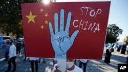 资料照:2020年10月1日,土耳其维吾尔族社区的一名抗议者在伊斯坦布尔市手举写着“停止,中国”的标语牌,抗议中国政府迫害新疆维族人。