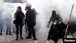 香港中文大学的学生们站在防暴警察发射的催泪弹烟雾中。(2019年11月12日)