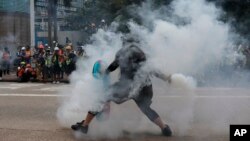 香港一名反送中抗议者把港警发射的一枚催泪弹抛回向港警。(2019年9月29日)