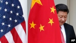 中国主席习近平从中国国旗后面走出来,参加白宫联合记者会(2015年9月25 日)