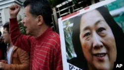 抗议人士在中国中央政府驻香港联络处外举行集会手举高瑜照片要求释放高瑜。(2015年11月27日)