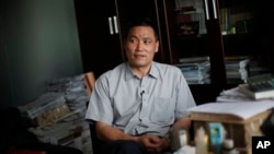 资料照:中国维权律师浦志强在便衣警察关注下在北京的办公室对媒体讲话。(2009年6月1日)