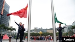 澳门警察在金莲花广场升起中国国旗和澳门特区旗帜。(2019年12月19日)