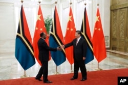 资料照:2019年5月28日,中国国家主席习近平在人民大会堂与瓦努阿图总理萨尔维(左)握手