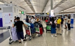新冠肺炎疫情下冷清的香港国际机场只有前往英国的登机柜台排满移居英国的人潮(美国之音/汤惠芸)