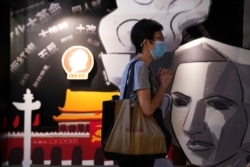 香港支联会负责营运的六四纪念馆,一名游客在一块刻有民主女神像的板子旁边祈祷