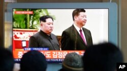 2019年1月8日在韩国首尔火车站,人们观看关于朝鲜领导人金正恩和中国国家主席习近平的电视新闻。